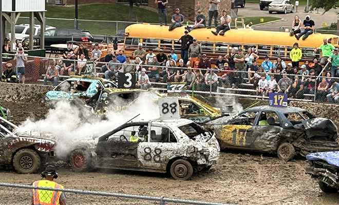 smashed up, muddy cars at the Carver County Fair Demolition Derby