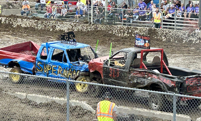 two brightly painted trucks crash during the Carver County Fair Demolition Derby