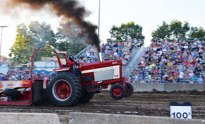 a tractor pulls a weighted sled at the Carver County Fair Out-of-Field Tractor and Truck Pull
