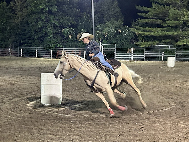 a man rides a horse around a barrel at the Carver County Fair
