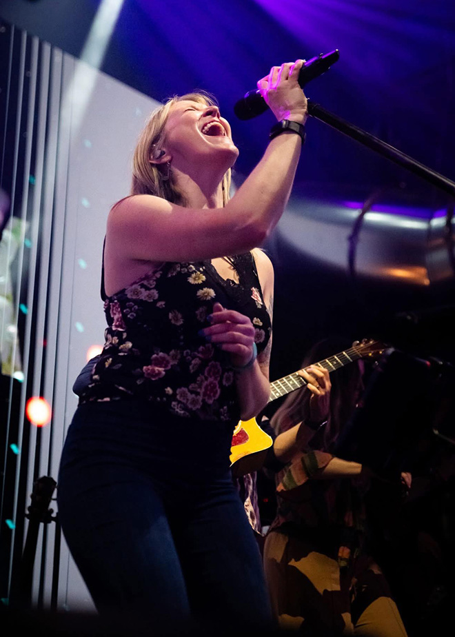 female singer of Ragtown tilts her head back as she sings into the microphone