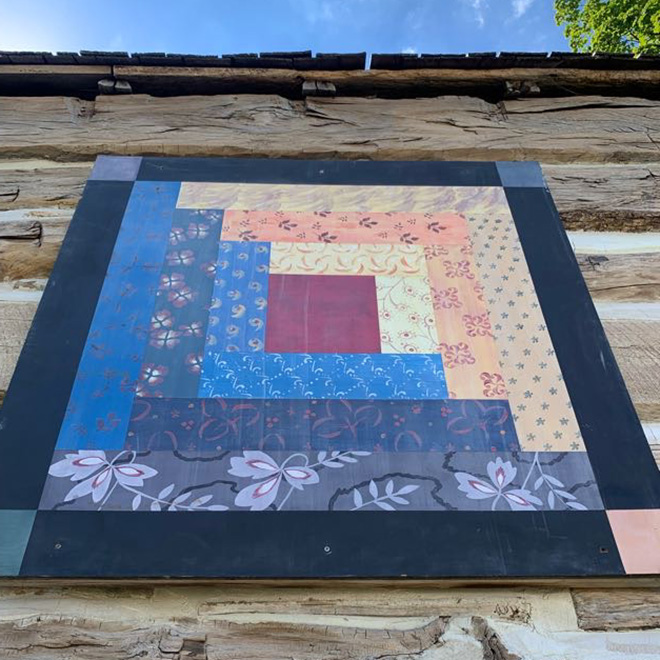 colorful barn quilt on the side of the CCHS log granary
