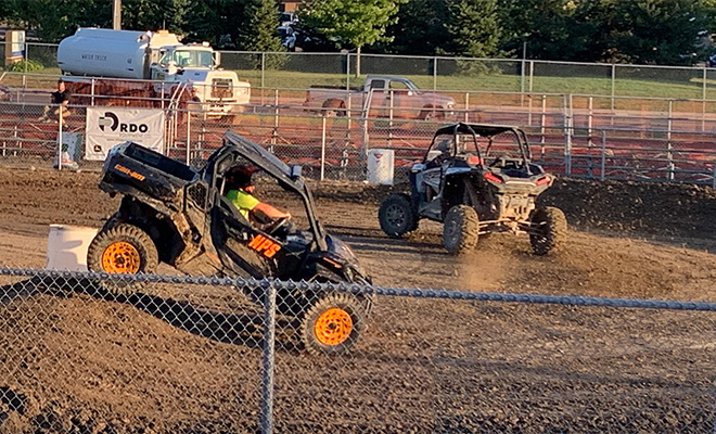 side-by-side UTVs racing on a track at the Carver County Fair