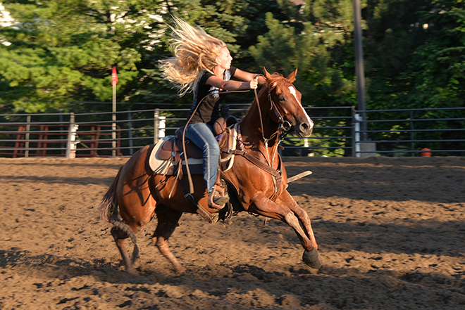 a woman rides a horse during a competition at the Carver County Fair