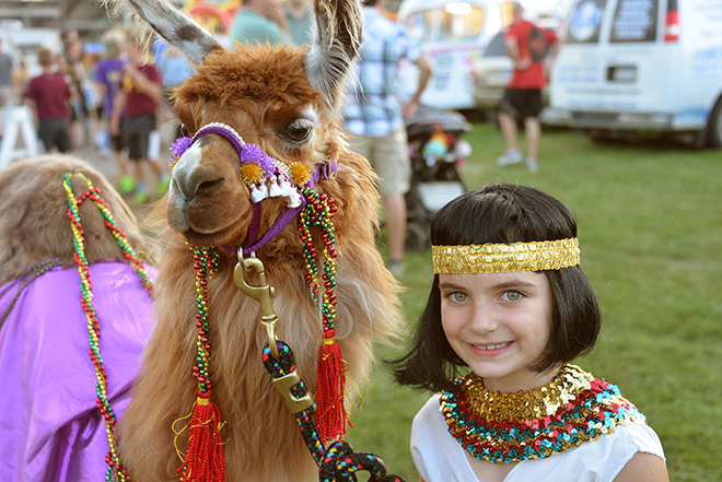 a girl poses with her llama in costume