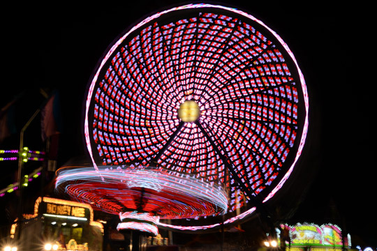 colorful lights on a ride in the Carver County Fair midway at night