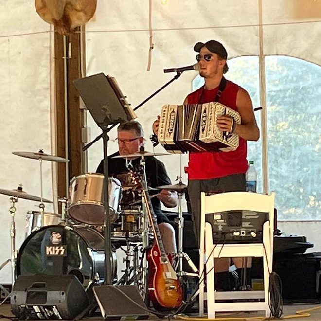 Colton Tupy performs accordion, accompanied by a drum set