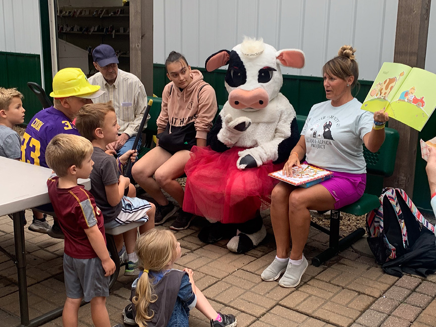 reading books with Tippy the cow mascot at the Carver County Fair