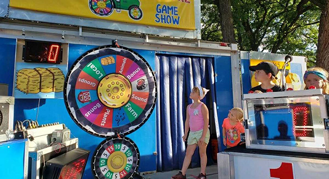 Wheels of Agriculture Game Show contestants watching the wheel spin